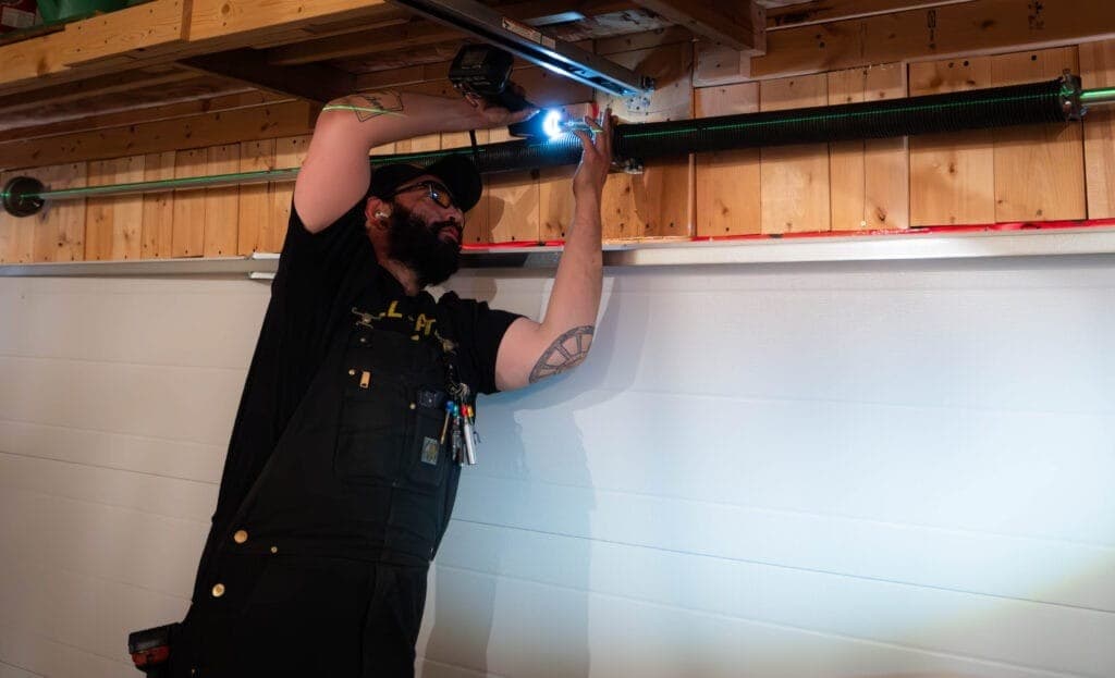 Garage Door Fix Edmonton technician handling an emergency garage door spring system repair